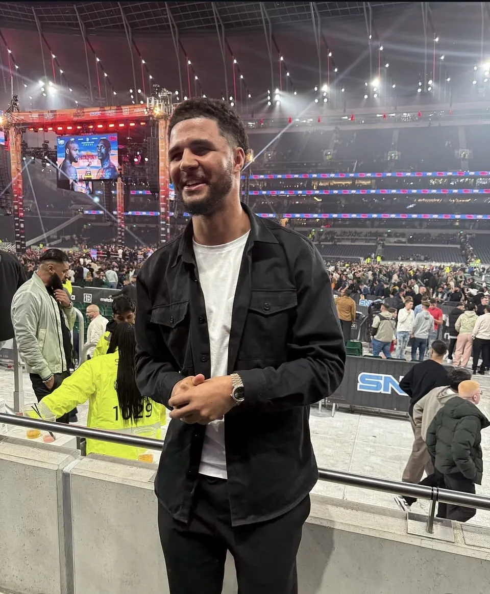 Tyson Isa smiling ringside at a boxing arena, out of fight kit.